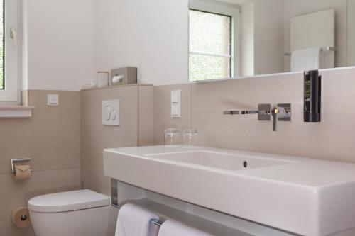 卡塞尔爱凤晨酒店的白色的浴室设有水槽和卫生间。