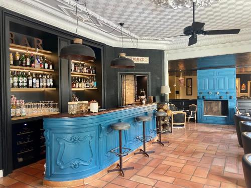 波尔尼谢Hotel de Charme Le Sud Bretagne的餐厅内带凳子的蓝色酒吧