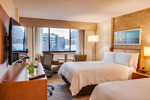 华盛顿Holiday Inn Washington-Central/White House, an IHG Hotel的酒店客房设有两张床和电视。