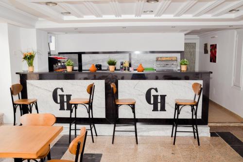 乌姆苏克LE GRAND HOTEL的餐厅设有酒吧,配有桌椅