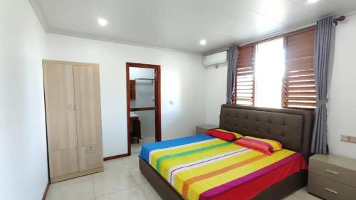 南迪Modern Master bedroom B的一间卧室配有一张带彩色毯子的床