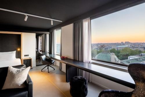 布鲁塞尔nhow Brussels Bloom的客房设有书桌和大窗户。