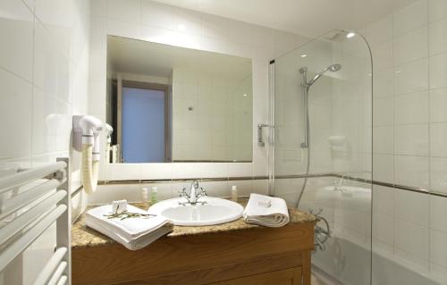 谷雪维尔Odalys Hotel New Solarium的一间带水槽、淋浴和镜子的浴室
