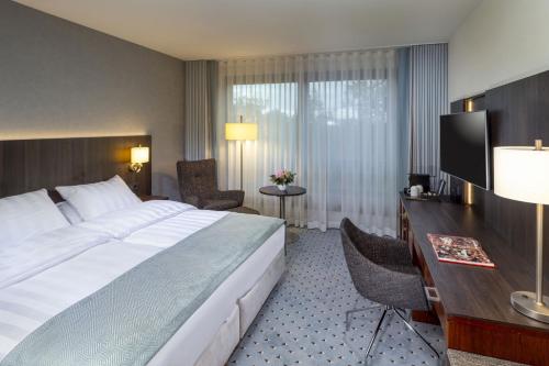 不莱梅玛丽蒂姆不来梅酒店的酒店客房设有一张大床和一张书桌。