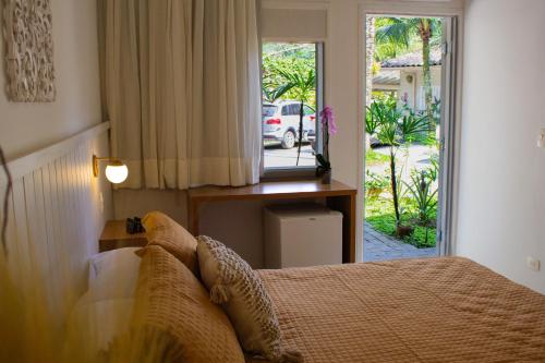 巴拉-沙希Casa Hotel Sahy的一间卧室设有一张床,一扇门通往庭院