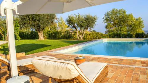 波滕扎皮切纳Villa Deliziosa - Homelike Villas的一个带两把椅子和遮阳伞的游泳池