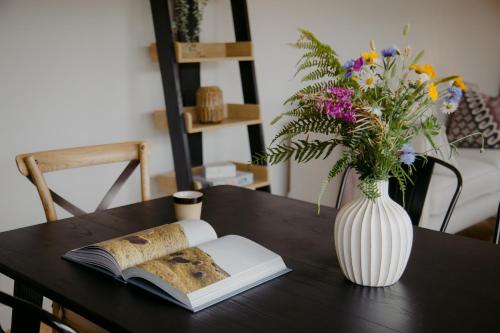 拉腊The Deerstone Luxury Eco Hideaway的花瓶和桌子上的一本书