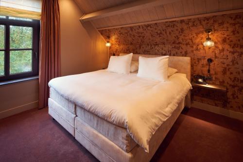 维格尔The Yard hotel Noordkade的卧室配有一张大白色床和窗户