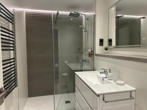 直布罗陀Marina Club - Luxury Apartment in Ocean Village with Parking的一间带玻璃淋浴和水槽的浴室