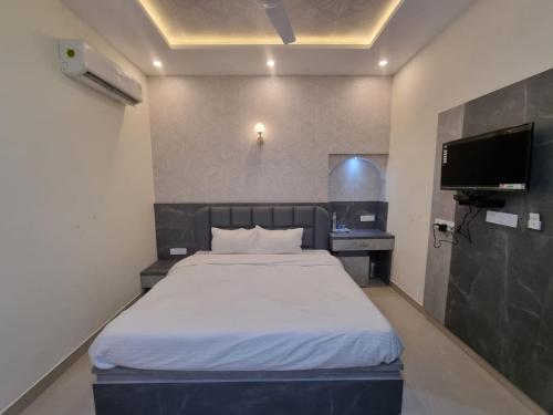 乌代浦Green Villa的一间卧室配有一张床和一台平面电视