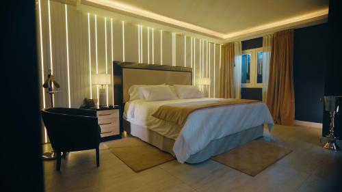 圣地亚哥-德尔埃斯特罗HT Hotel Deluxe Resort & SPA的一间卧室配有一张床、一张桌子和一把椅子
