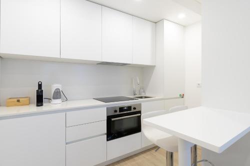 拉梅戈FAFEL LITTLE HOUSE - Quinta de Cravaz的白色的厨房配有白色橱柜和水槽