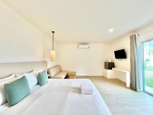 罗勇Sunvada Beach Rayong的白色的卧室设有一张大床和一个窗户