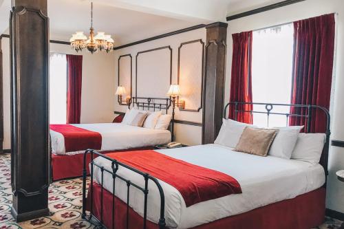 托诺帕米兹帕酒店的配有红色窗帘的酒店客房的两张床