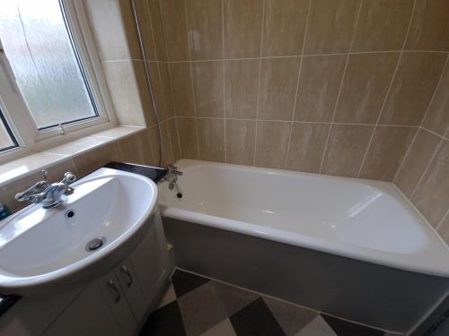 奥尔德伯里Walker Lodge的浴室配有白色浴缸和水槽