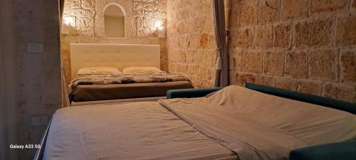 奥斯图尼La Casuccia的砖墙客房的两张床