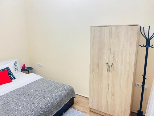 阿拉木图Like Home Rooms的一间卧室配有一张床和一个木制橱柜