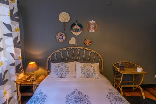瓦尔帕莱索Val Paradou - ex - Casa Magnolia的卧室配有一张带枕头和盘子的床铺,墙上挂有枕头。