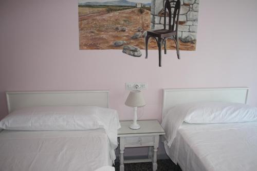 菲格拉斯伊莎贝尔二号旅馆的一间设有两张床和一张椅子的墙壁客房