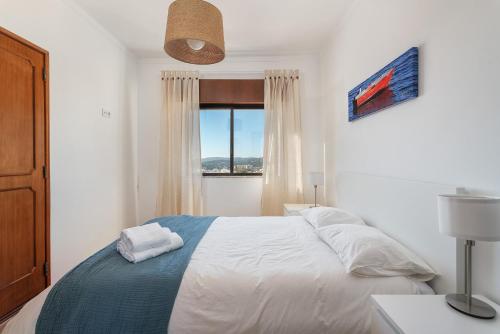楼尔Spacious & Sunny Flat - Loulé的白色的卧室设有床和窗户