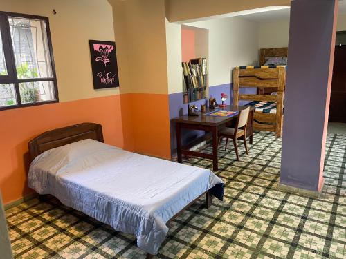 科恰班巴El Pueblito的一间卧室配有一张床、一张桌子和一张桌子