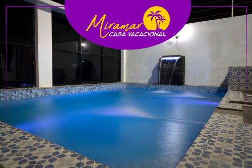 通苏帕MIRAMAR Casa Vacacional Frente al mar的上面有一个紫色标志的大型游泳池