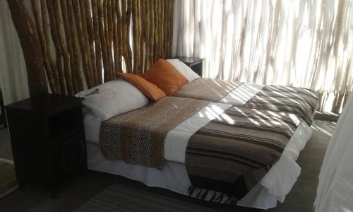 GrootfonteinParadise Camp delux Rooms的卧室配有带枕头的床铺和窗户。