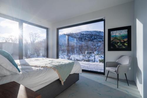 基尔匹斯扎我维Aurora View Lapland, Sky View Bedroom & Jacuzzi的一间卧室设有一张床和一个大窗户