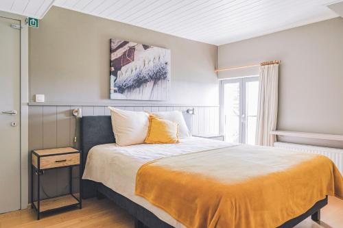 马尔德海姆De Burkelhoeve appC的一间卧室配有一张黄色毯子床
