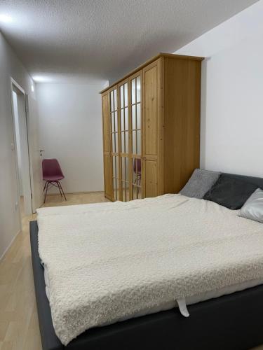 兰茨胡特Helle Zwei-Zimmer-Stadt-Wohnung am Bismarkplatz mit Tiefgarage的一间卧室配有一张大床和一个木制橱柜