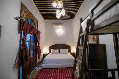 非斯Riad Fes Tala的一间卧室配有一张床和两张双层床。