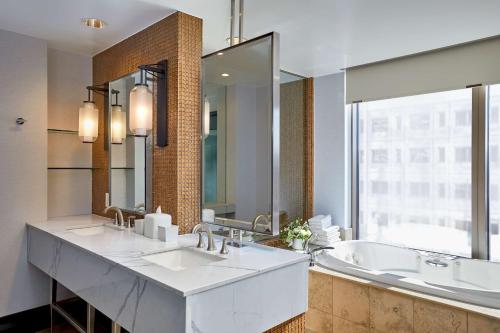 西雅图Hotel 1000, LXR Hotels & Resorts的一间带两个盥洗盆和大镜子的浴室