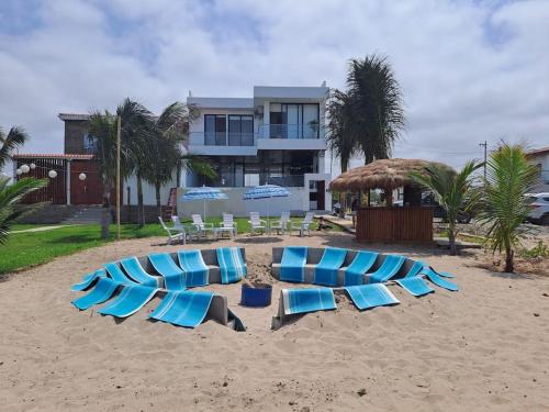 蒙塔尼塔Hermosa casa frentes al mar en Montanita con piscina的海滩上的蓝色躺椅