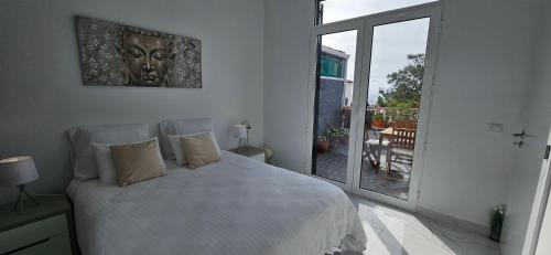 丰沙尔Casa da Loba的白色的卧室设有床和大窗户