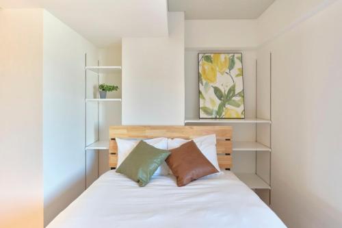 东京Modelo Sangenjaya - Vacation STAY 15699的一间卧室配有带白色床单和枕头的床。