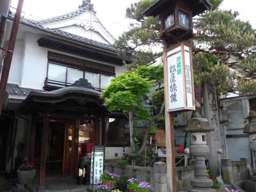 长野吉扎肯松屋旅馆的前面的柱子上有一个钟的房屋