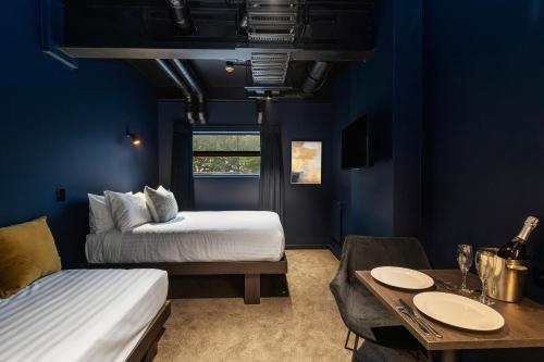 奥克兰Abstract Hotel & Residences的蓝色客房 - 带2张床和1张桌子以及1间用餐室