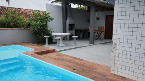 巴尔内阿里东海滩Casa beira mar的一个带桌子和游泳池的庭院