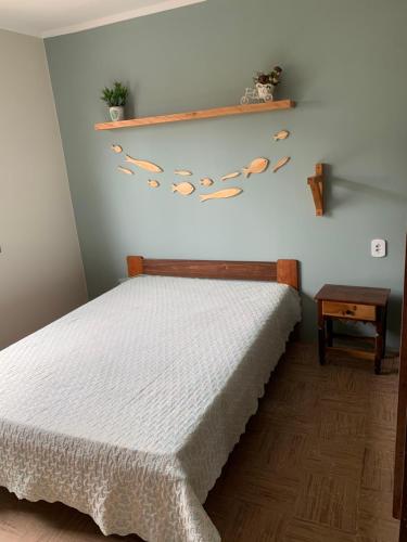 巴尔内阿里东海滩Casa beira mar的卧室配有一张床,墙上有树叶架