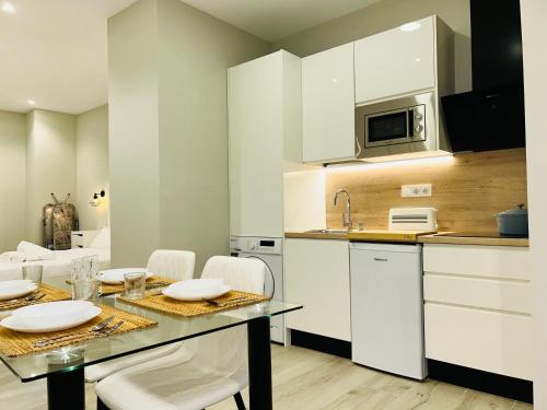 科尔多瓦RIBERA HOME 2的厨房配有白色橱柜和桌椅