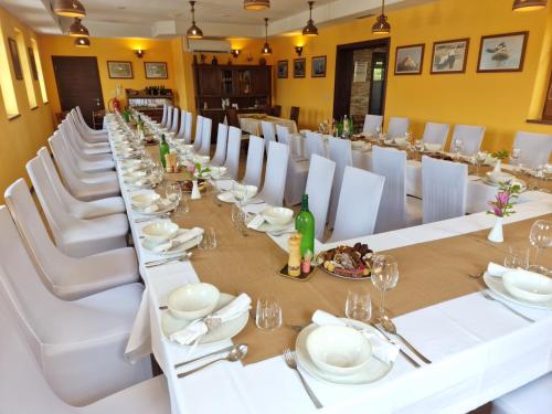 摩拉瓦托普利采Pri štorklji的长餐厅设有白色的桌子和白色的椅子