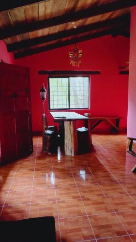 SiguatepequeEl Gran Chaparral的一间设有桌子和红色墙壁的房间