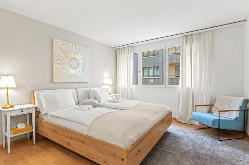 卢塞恩Bright, Central & Modern apartment的一间卧室配有一张大床和一张蓝色椅子