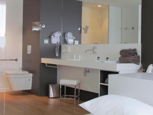 加龙河畔波泰Hotel L'Hotan的一间带水槽、卫生间和镜子的浴室