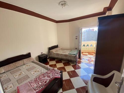 马特鲁港شقق فندقيه برج شيفورليه حي الدولار的小房间设有两张床,铺有瓷砖地板。