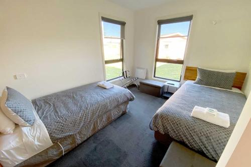 斯特拉恩Wild Rivers Escape的一间卧室设有两张床和两个窗户。