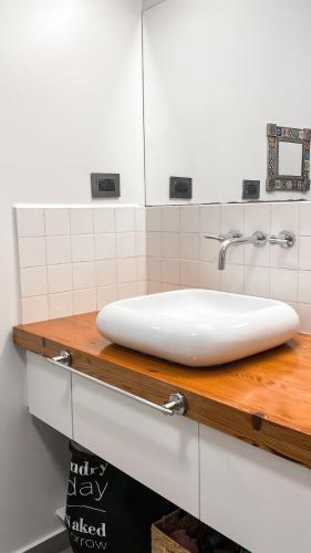 卡塔马卡Casa Feliz的浴室内木制柜台上的白色水槽