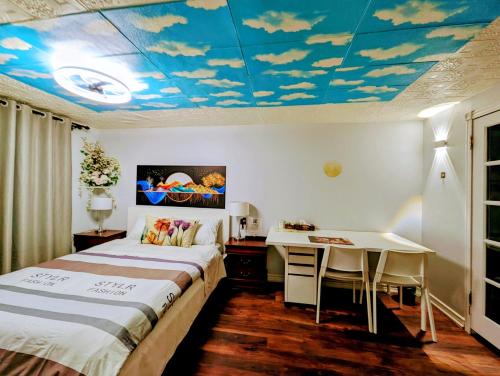 多伦多Cozy and quiet house with private swimming pool的一间卧室配有一张床和一张书桌,天花板上云彩缤纷。