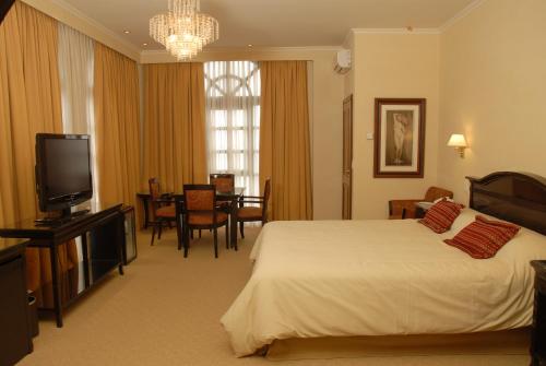里奥格兰德Status Hotel的酒店客房,配有床和电视