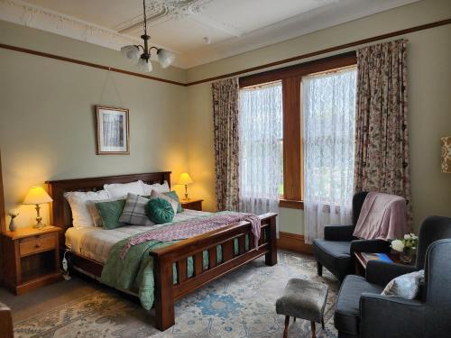 巴尔克拉萨The Fern & Thistle Luxury Accommodation- Drinks, Hotpool, Sauna的一间卧室配有一张床、一把椅子和窗户。
